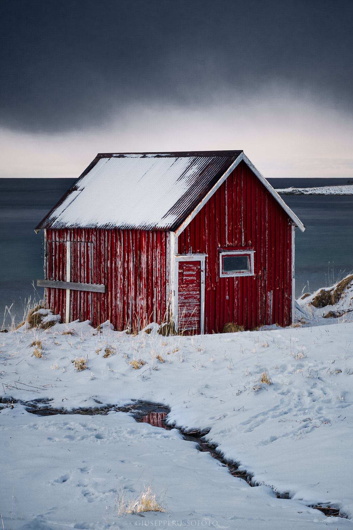 Casetta rossa rorbu sotto la neve